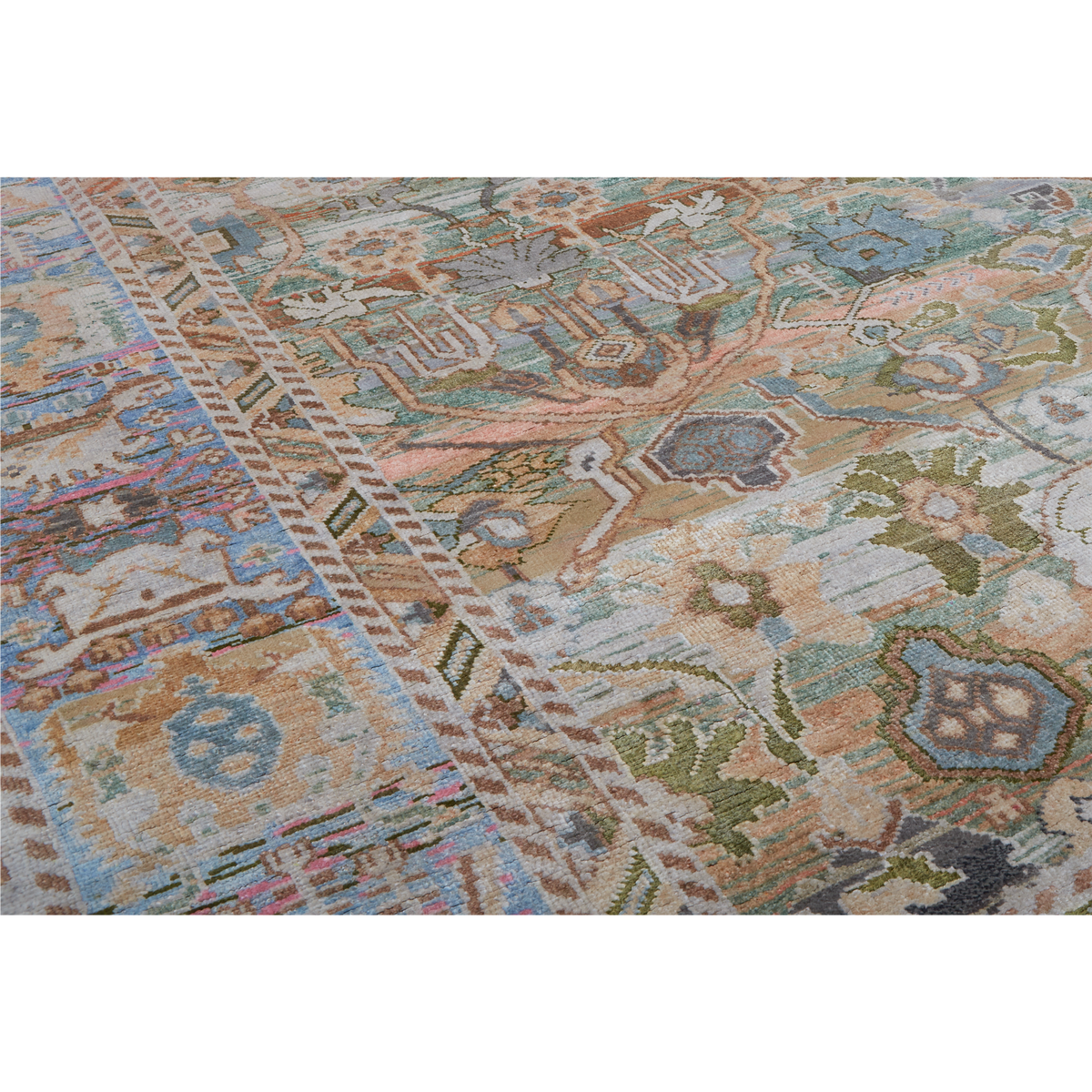 A close-up of a traditional patterned area rug with a complex geometric and floral design in muted tones of beige, blue, green, and brown.