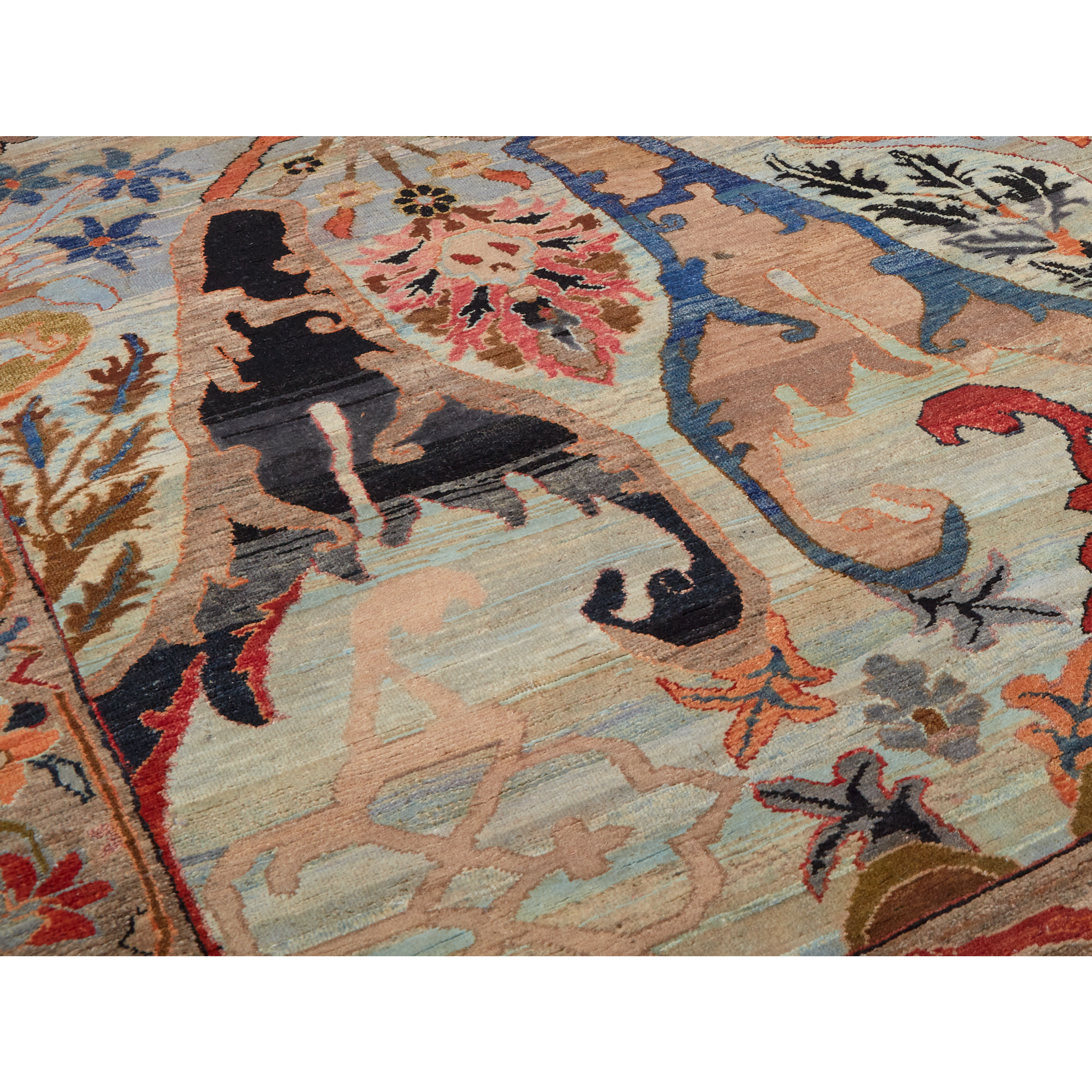 A close-up of a patterned area rug with a traditional design in beige, blue, black, red, and brown tones.