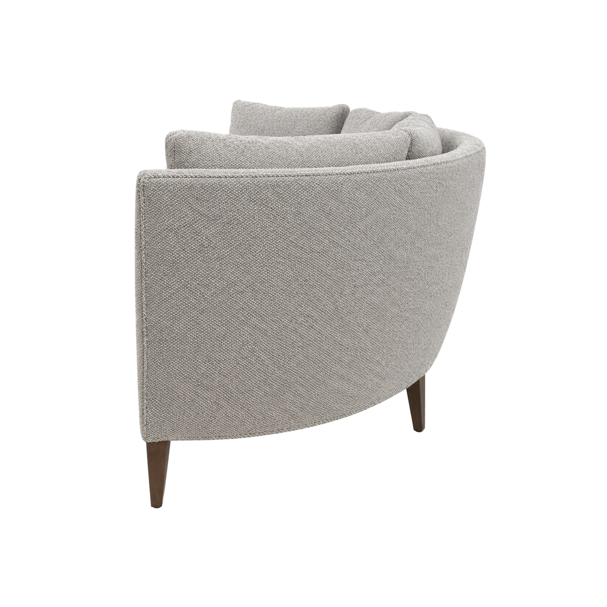 Parker Sofa in oatmeal bouclé, angled side view highlighting the curved silhouette, stacked loose cushions, and tapered wood leg.