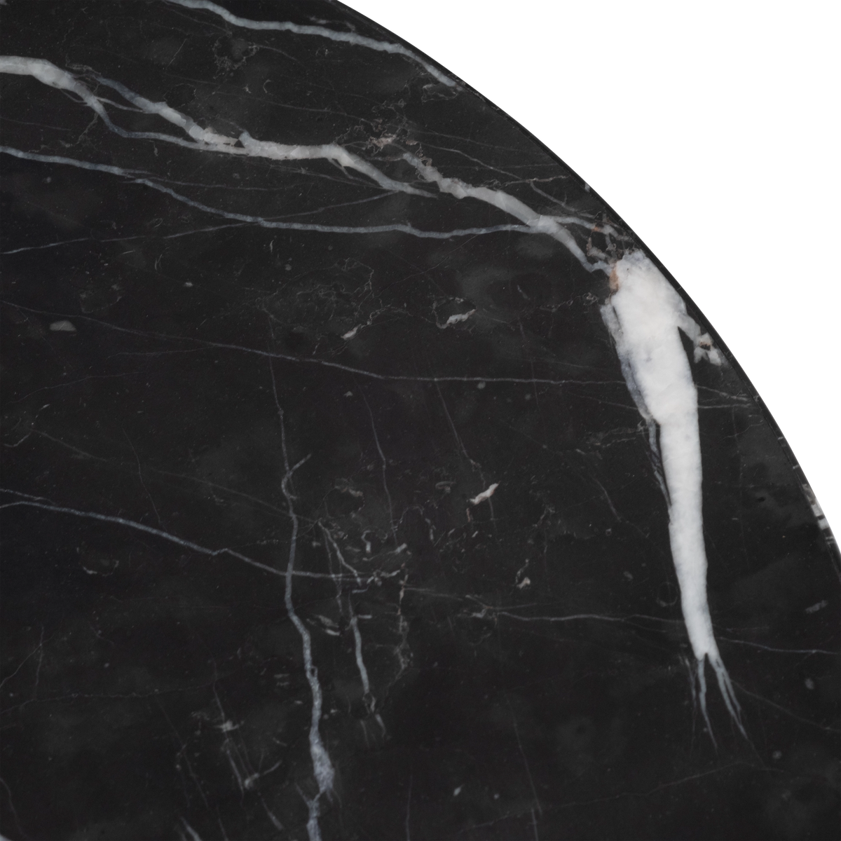 Close-up showing the top of the Meta Round Side Table in Black Nero Marquina marble, with a thick white vein reaching the edge and fine pale hairline veining across the honed surface.