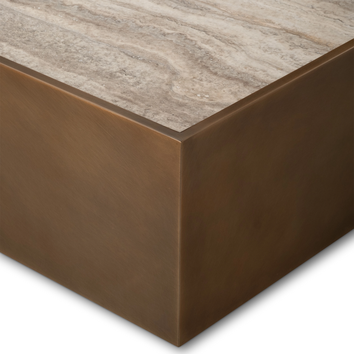 Close-up of the corner of the Pedra Rectangular Coffee Table in Aged Bronze, showing the crisp mitered metal edge and the fine veining of the taupe travertine top.