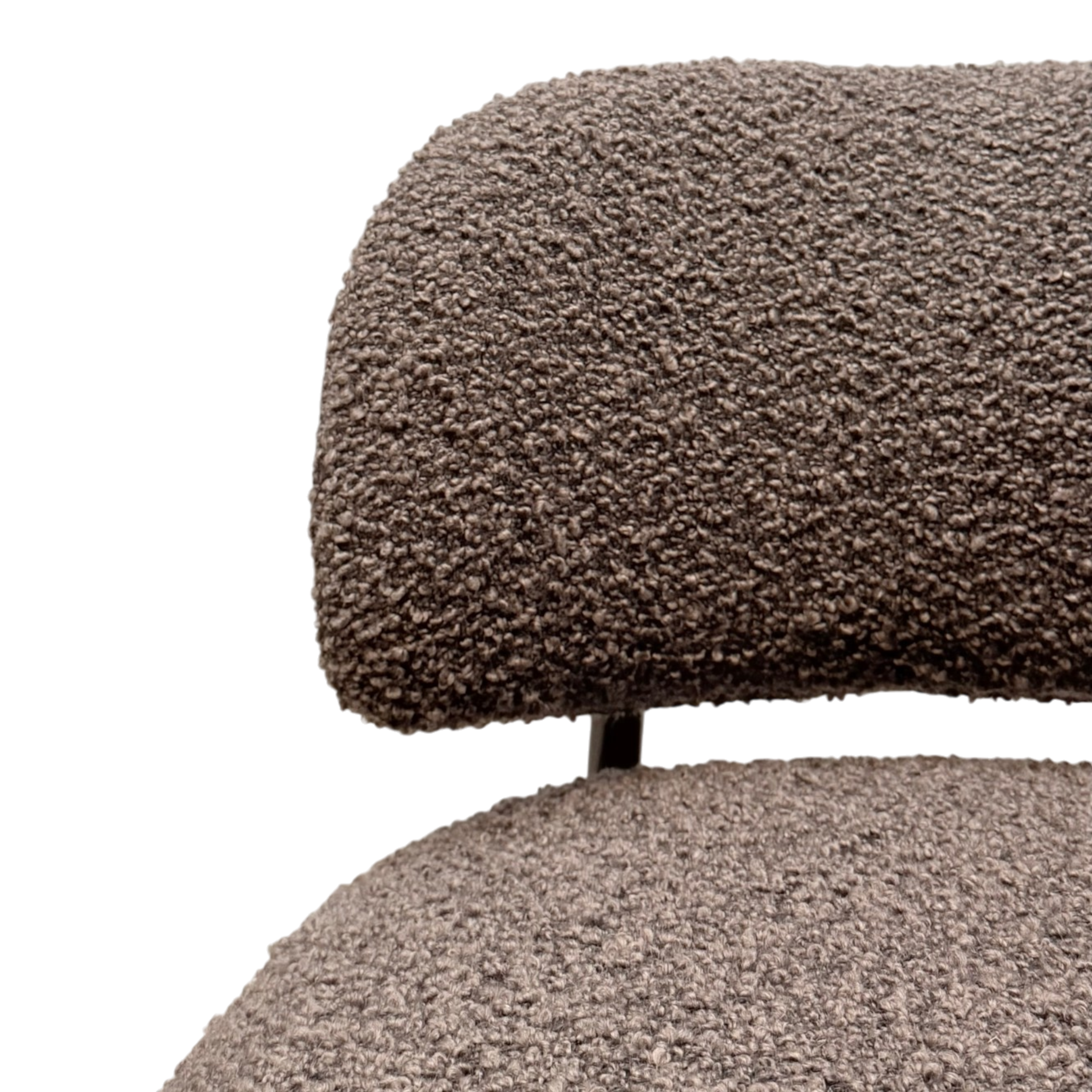 Close-up of a textured boucle upholstered chair with a rounded backrest and seat, shown against a plain white background.