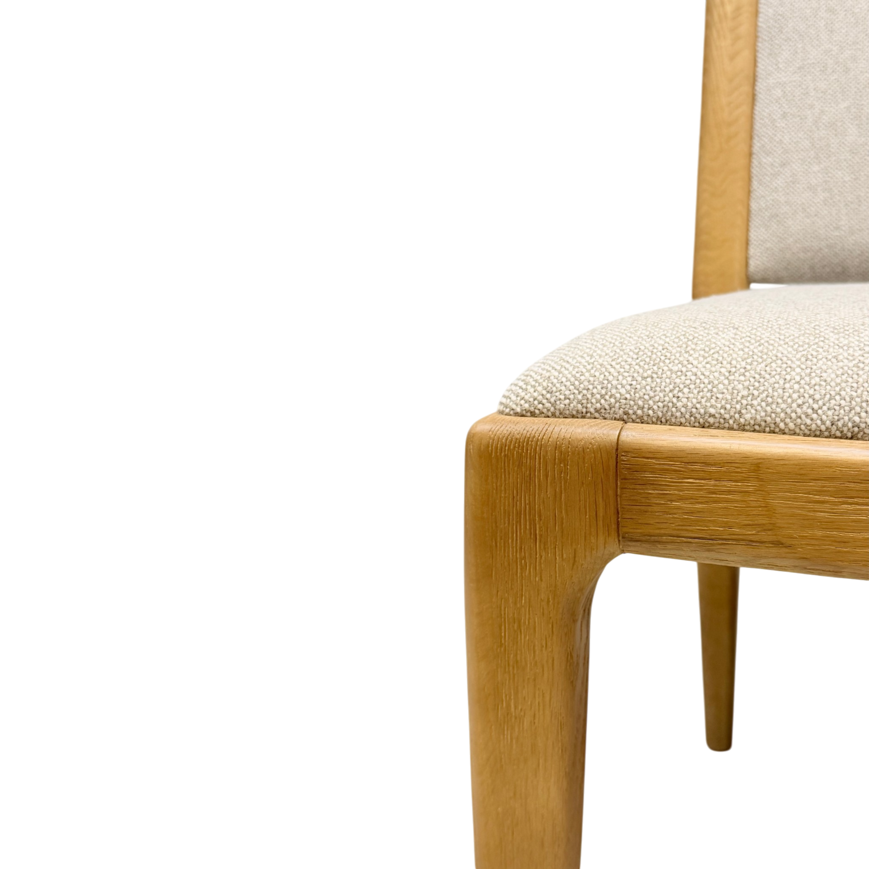 Close-up detail of a wooden dining chair showing the light oak frame, upholstered seat cushion, and backrest on a solid white background.