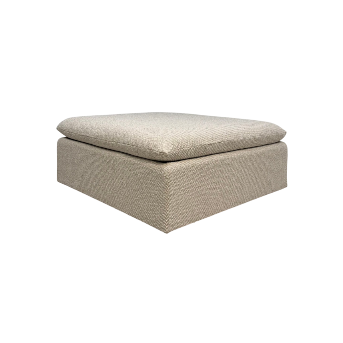 Tempo Modular Ottoman in an angled view with ivory textured upholstery, a low-profile rectangular base, and an oversized loose cushion.