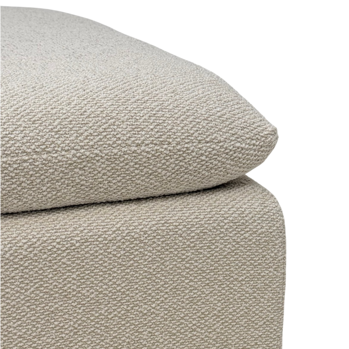 Tempo Modular Ottoman close-up showing the textured ivory upholstery and the softly rounded edge of the oversized cushion over the upholstered base.