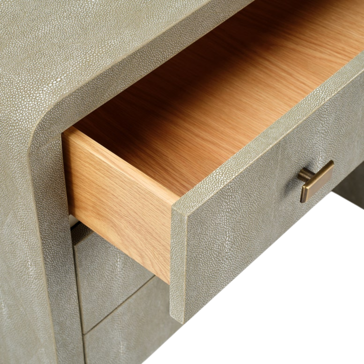 Detail of an open drawer on the Harlow Nightstand in Soft Sage faux shagreen, showing the wrapped drawer front, metal pull and warm wood-toned interior.