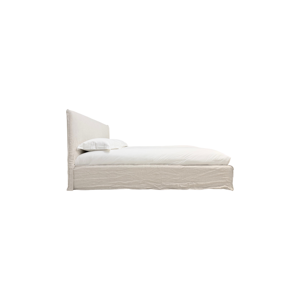 Muse Queen Bed in natural linen, side profile showing the slim upholstered headboard, low bed frame, white bedding, and floor-length slipcover.