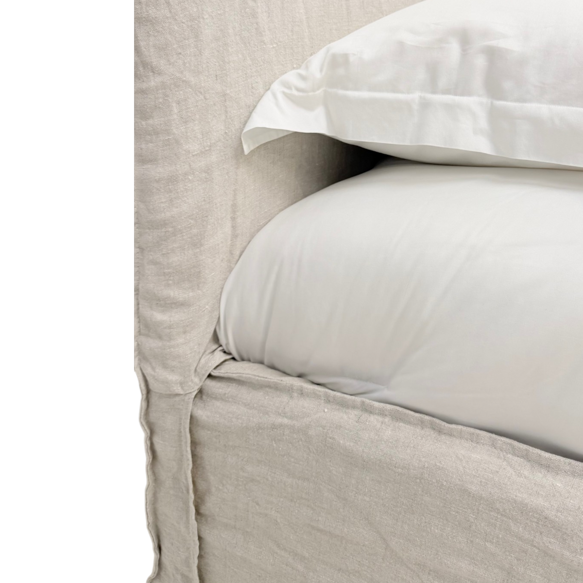 Close-up of the Muse Queen Bed highlighting the natural linen upholstered headboard and frame alongside smooth white bedding.