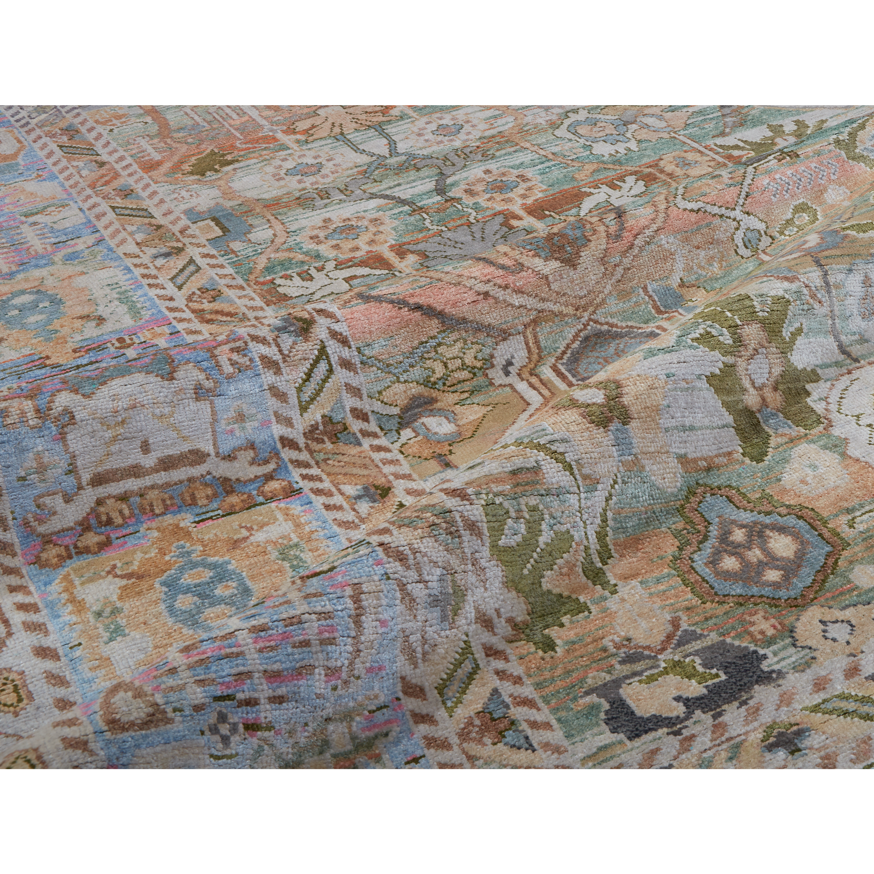 A close-up of a vintage-style area rug with an intricate, faded multicolor pattern featuring beige, blue, green, and brown tones.