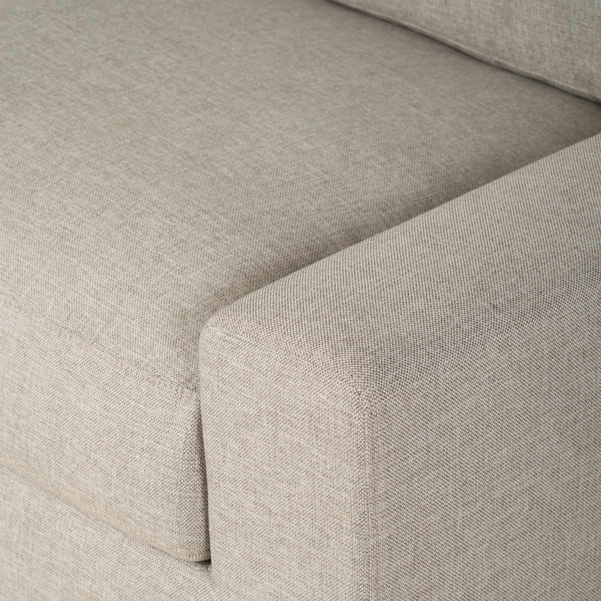 Close-up showing the seat cushion, square arm, and back cushion edge of the Montara Sofa in Pumice woven fabric, with a fine, heathered texture.
