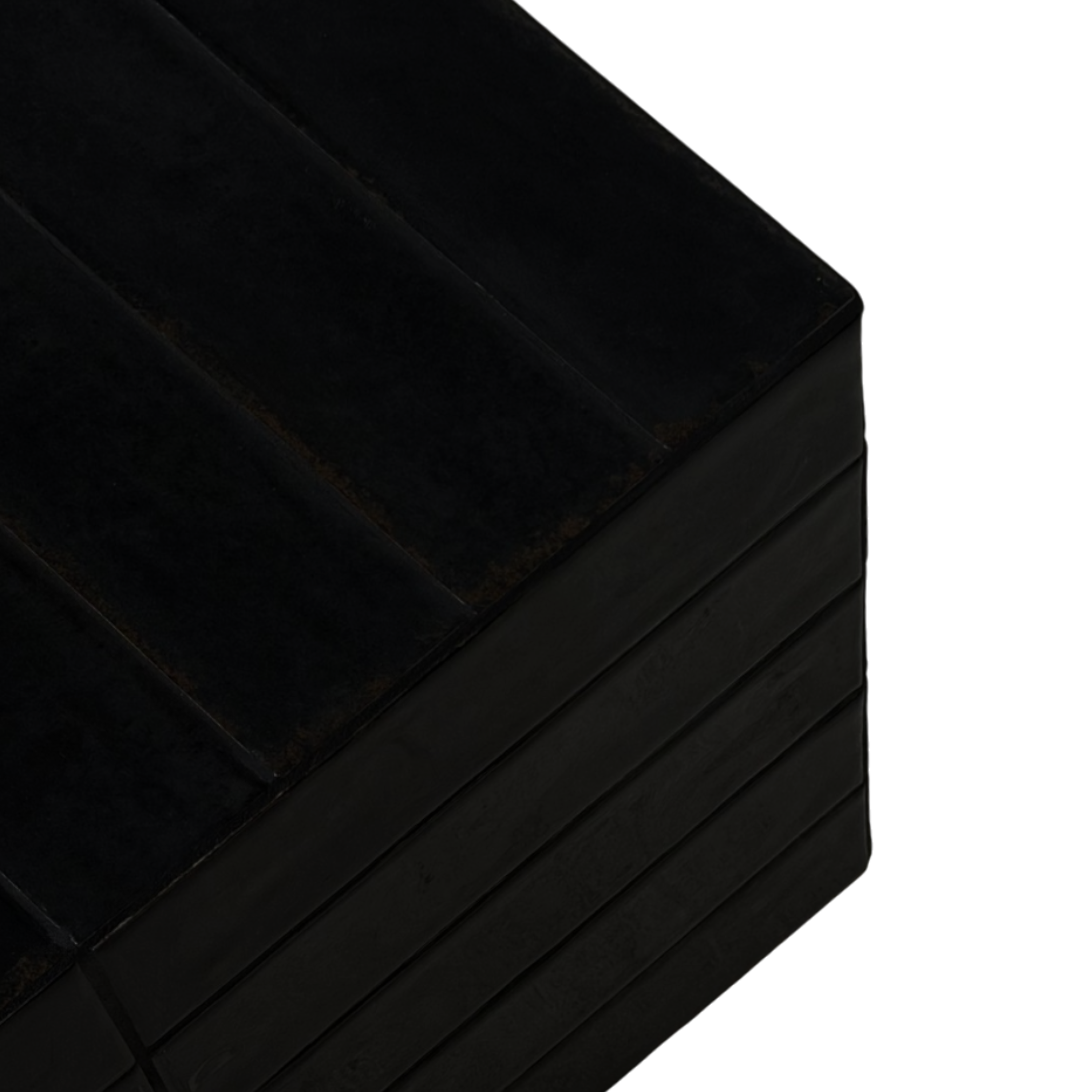Bloom coffee table is a close-up studio shot of a stack of thick, black rectangular blocks or pads with a matte finish, shown against a solid white background.