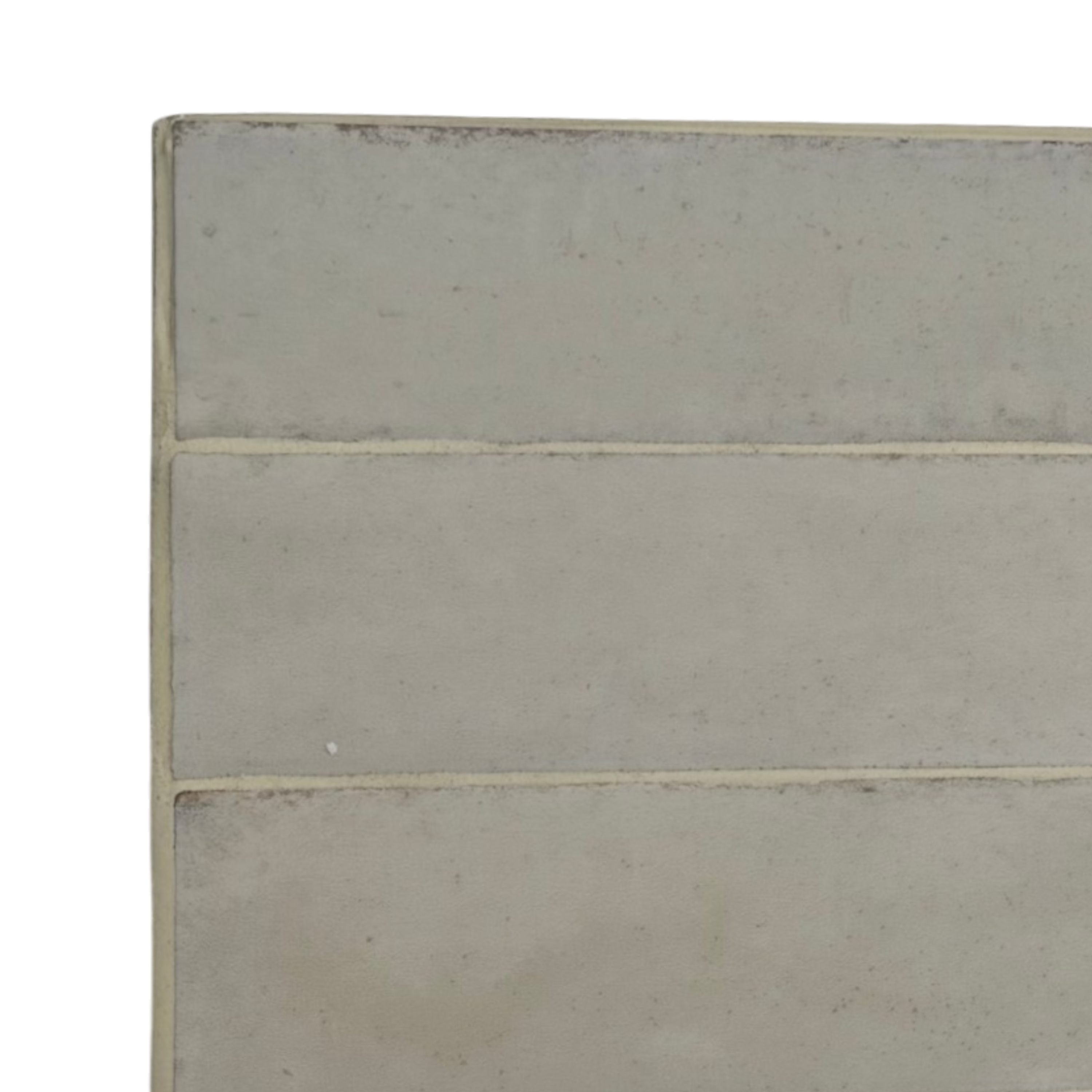 A close-up of a rectangular ceramic tile with a distressed, textured matte finish in a light gray-beige color, showing horizontal grout lines and a slightly uneven top edge.