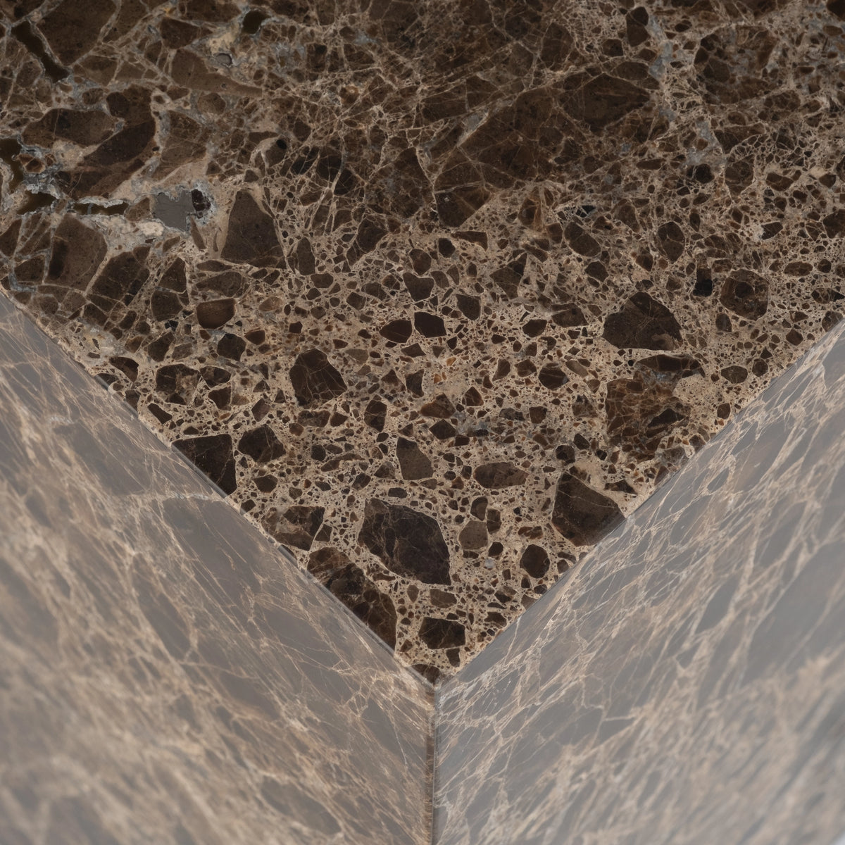 Close-up showing the top corner of the Meta Square Side Table in Chocolate Brown Dark Emperador marble, with dark brown stone fragments framed by fine pale tan veins.