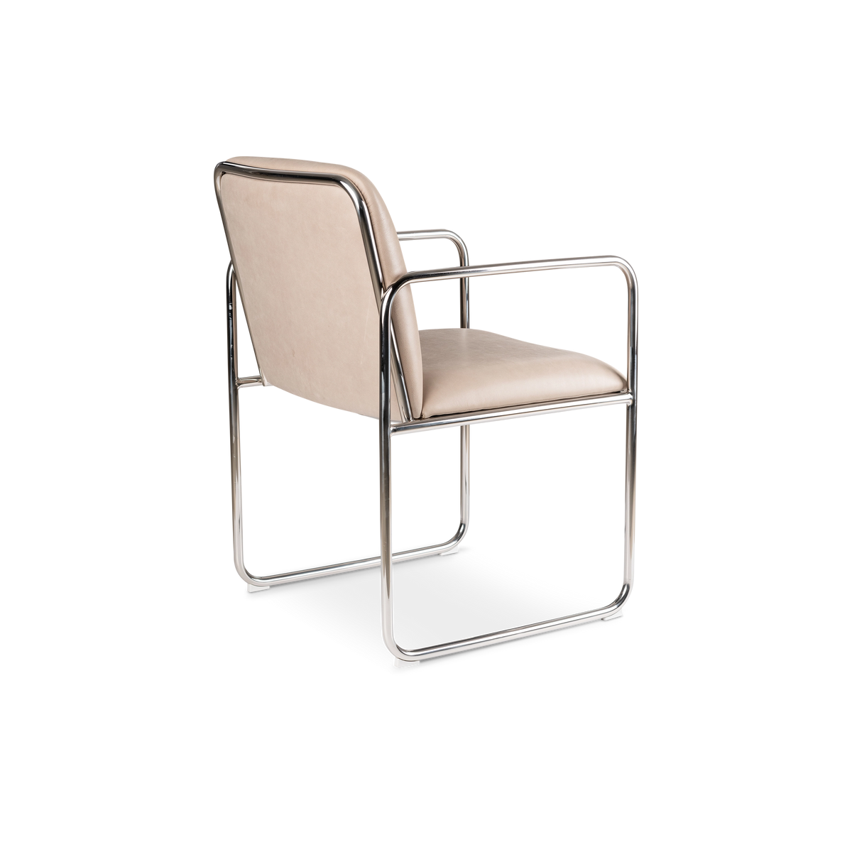 Rhodes Arm Chair angled from the back in taupe top grain leather, showing the upholstered back panel framed in polished steel and the sled-style base.