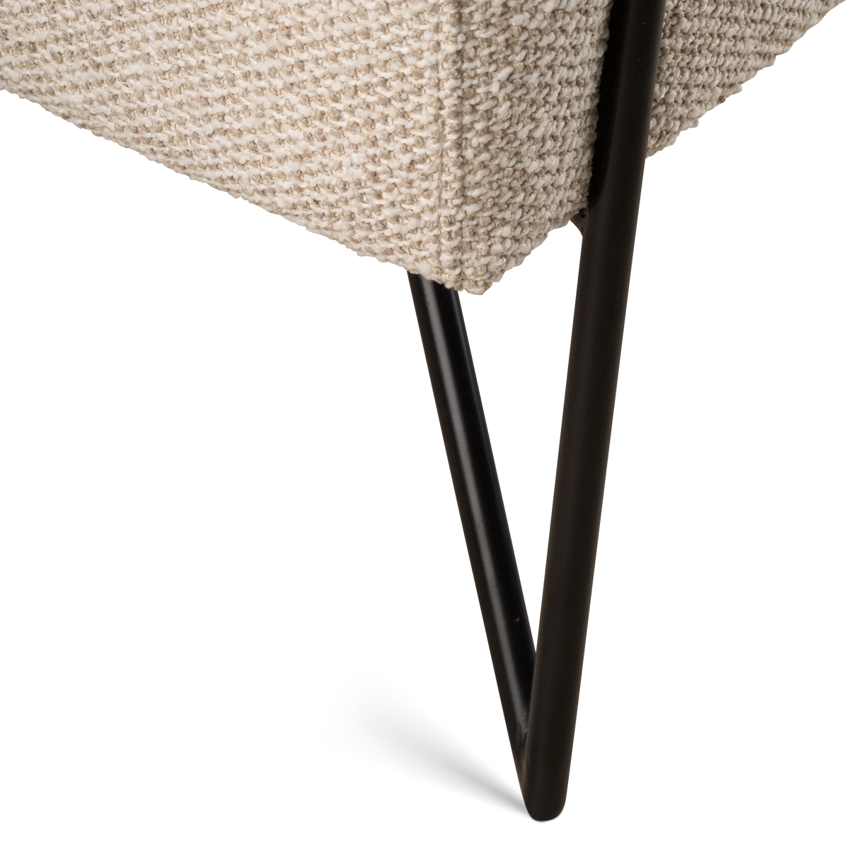 Close-up showing the seat edge of the Knox Lounge Chair in oatmeal woven fabric, with a clean seam and a black metal V-shaped leg beneath.