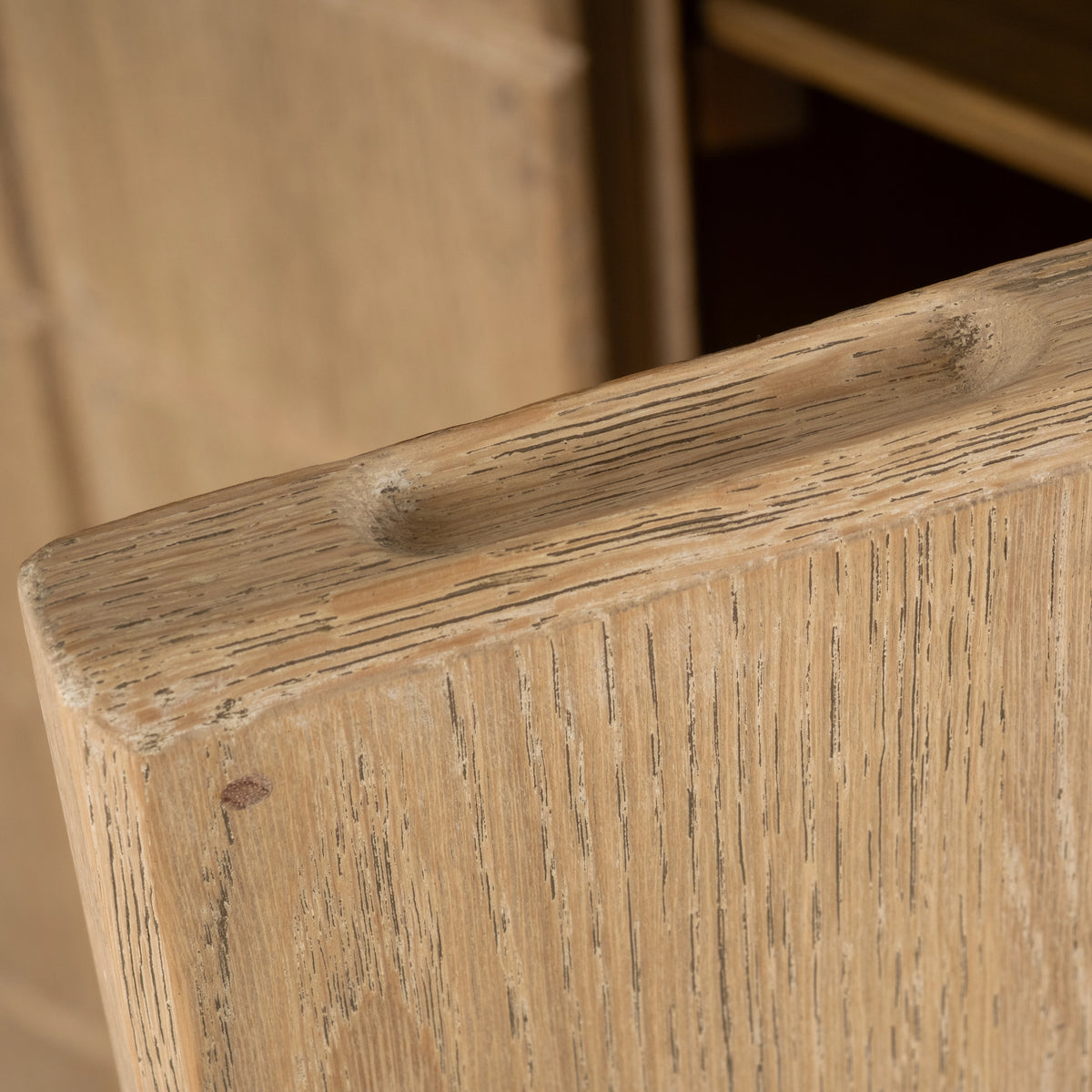 Close-up showing the scooped pull and rounded top edge of the Rosedale Cabinet in light tan oak, with open grain and a softly limewashed finish.
