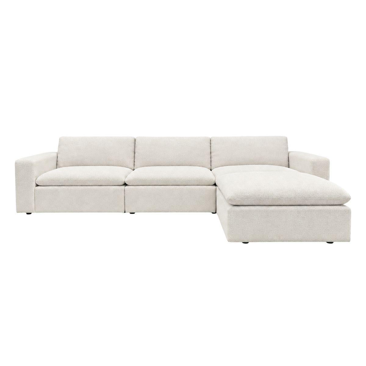 Tempo Modular Sectional shown from the front in heathered greige textured upholstery, with wide arms, three loose back cushions and an ottoman extending the right end into a chaise.