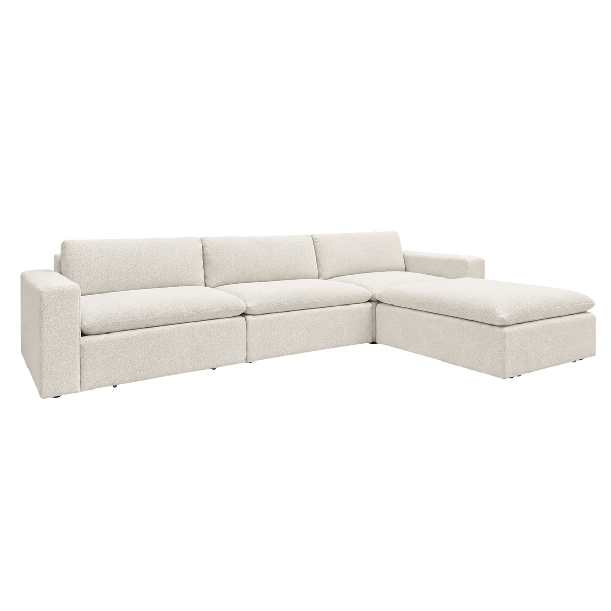 Tempo Modular Sectional angled view highlighting the low profile in heathered greige upholstery, with wide slab arms, oversized loose cushions and the chaise ottoman at the right end.