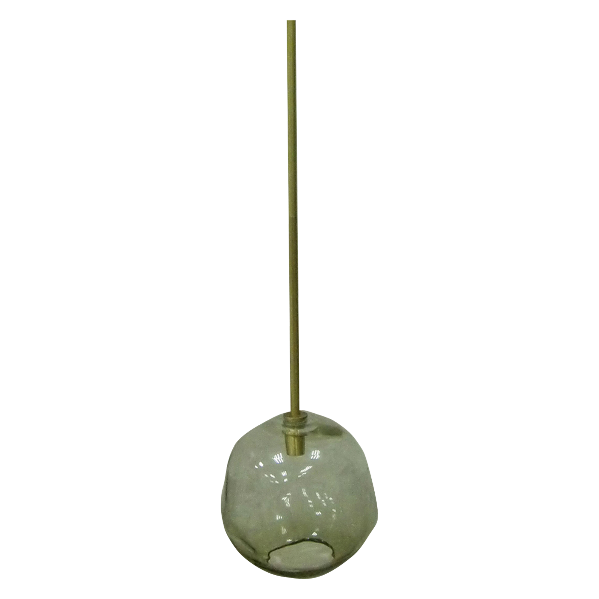 A smoked glass orb with an organic, irregular silhouette hangs from a brass rod in this elegant and natural pendant.